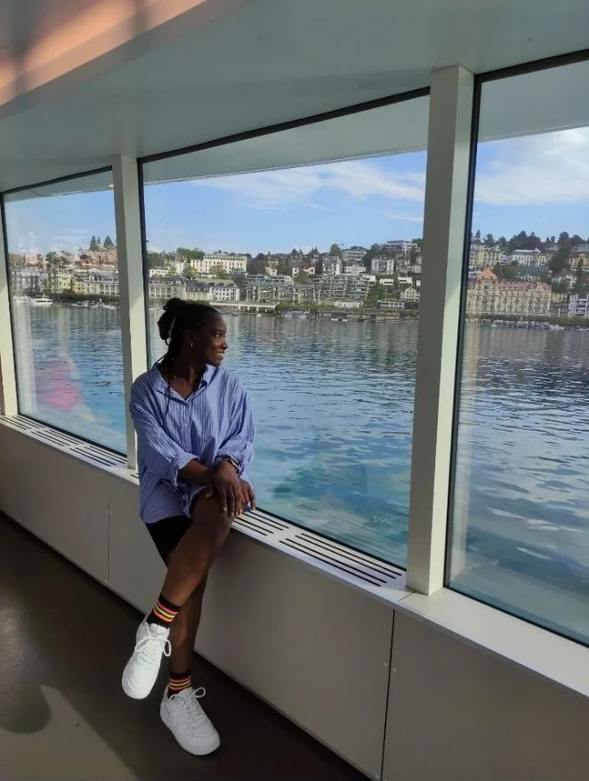 The founder looking out of a boat window across a lake and a hillside town