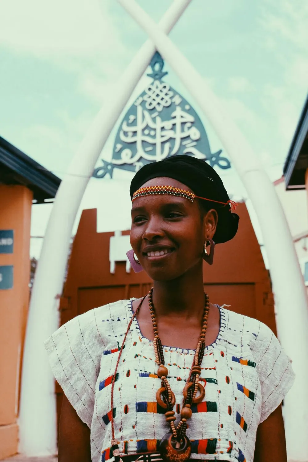 A smiling woman in a beaded headband and embroidered top